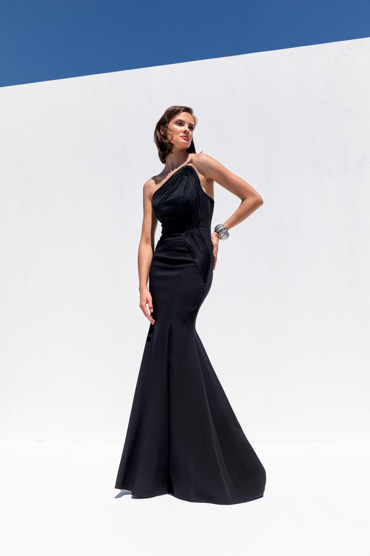 Black one-shoulder crepe mermaid gown with pleated fan detail