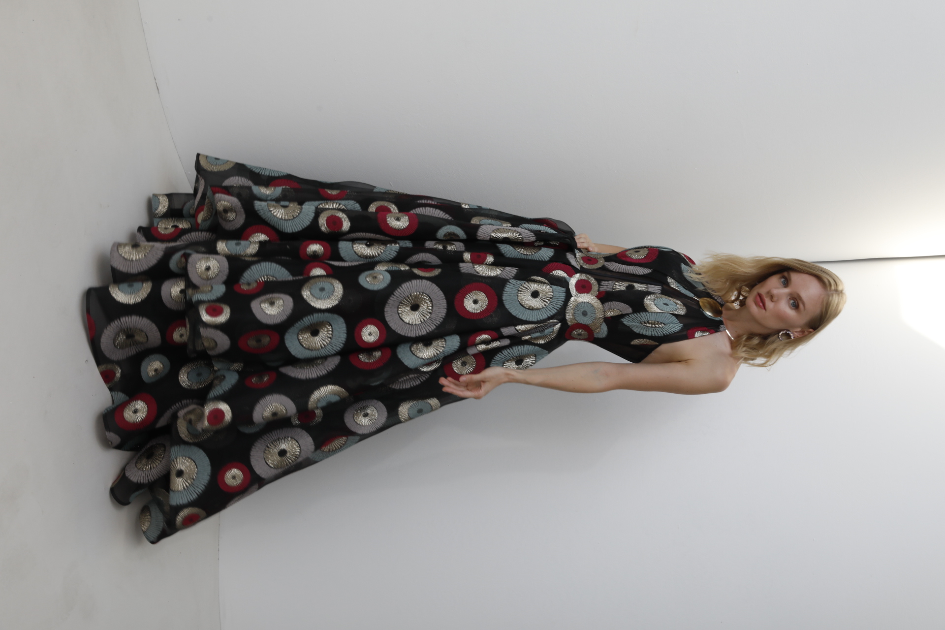 Black organza halter gown with metallic circle embroidery and tiered skirt