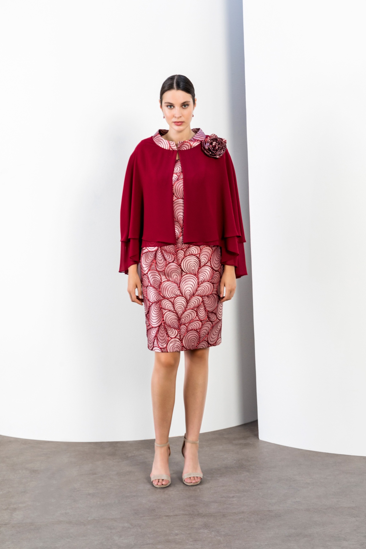 Burgundy chiffon cape over patterned pencil dress with rose corsage