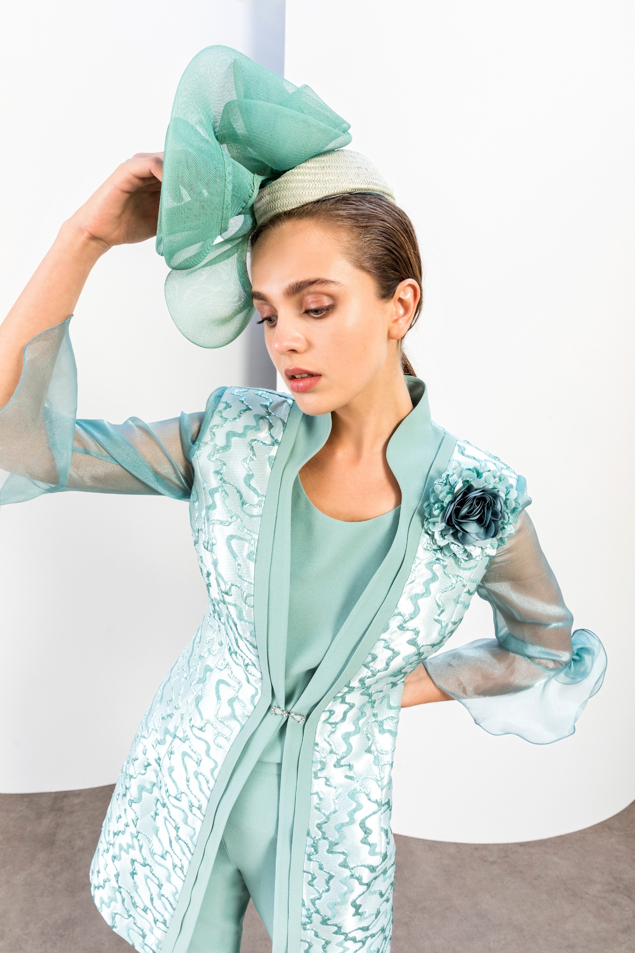 Mint green metallic jacquard trouser suit with organza sleeves and fascinator