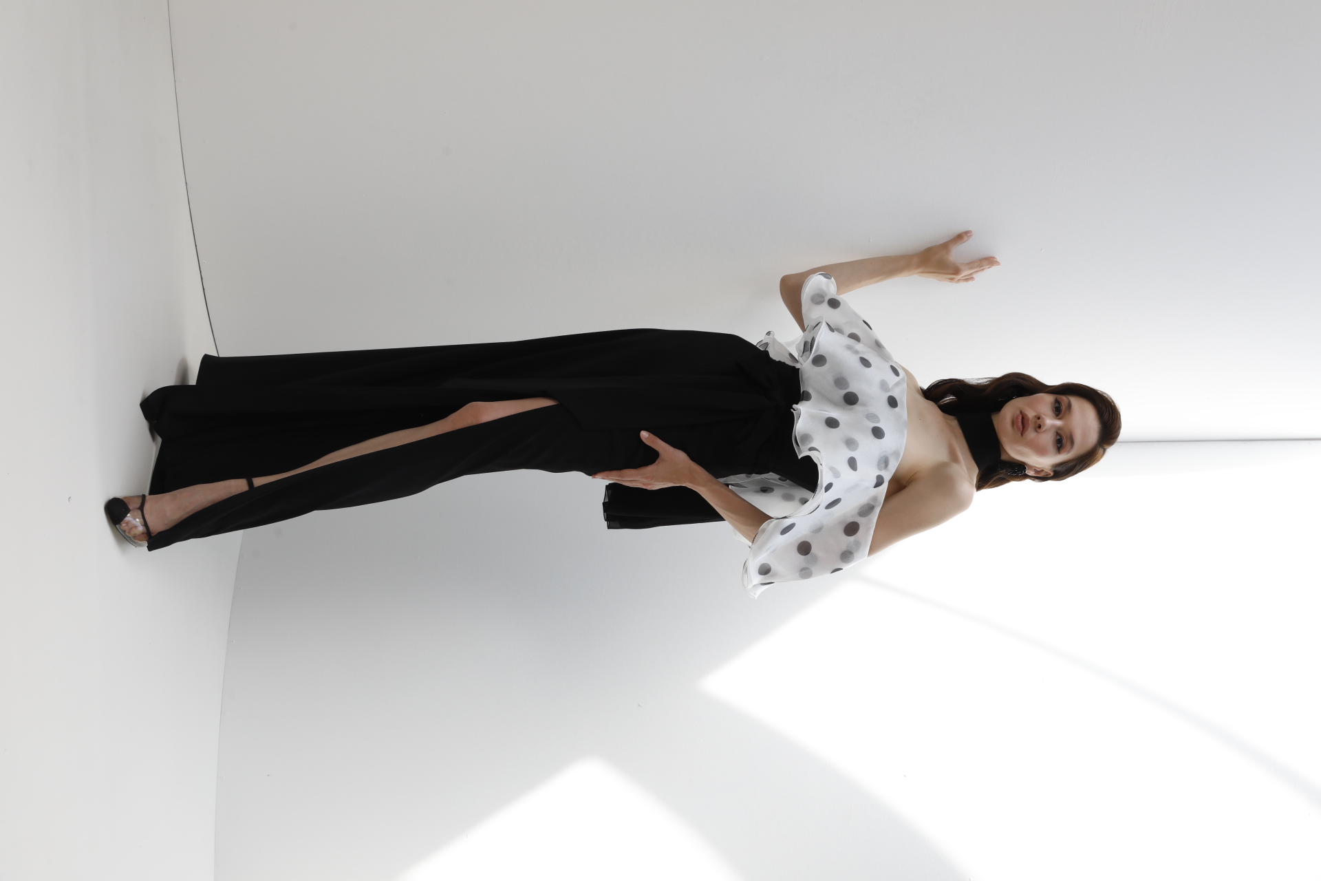 Black gown with polka dot organza off-shoulder ruffle and high slit