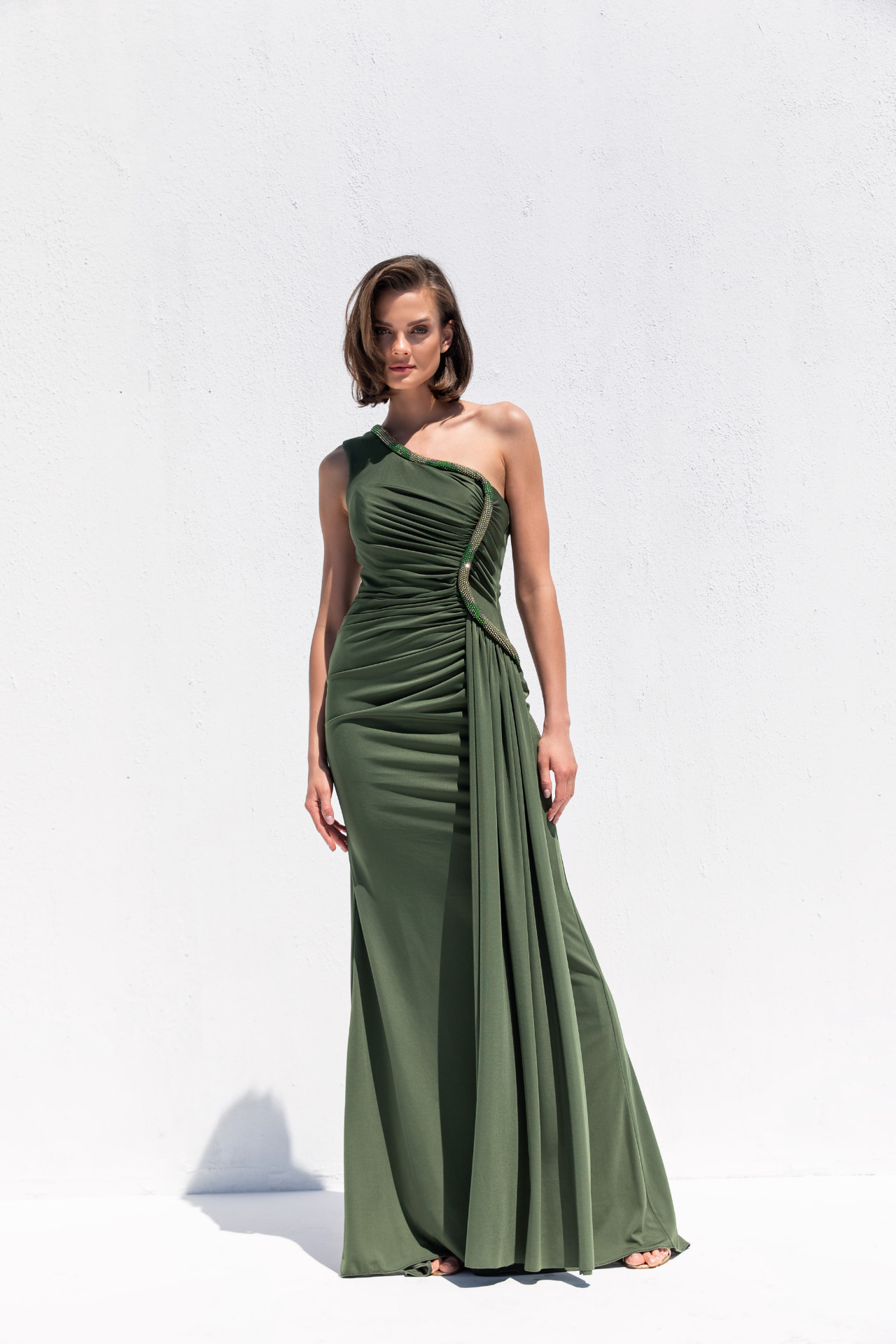 Olive one-shoulder draped jersey gown with emerald crystal trim